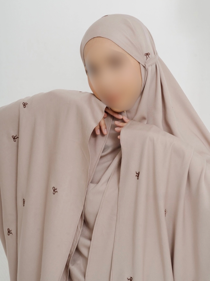 Soft and feminine prayer outfit laid out with delicate ribbon accents and modest design